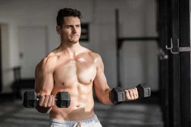 Μυώδης άνδρας που κάνει άρση βαρών στο γυμναστήριο